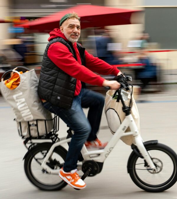 A man rides an electric bike through a lively street in Stuttgart, Germany.