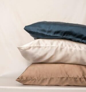 Aesthetic stack of silk pillows in blue, white, and beige for a luxurious touch.